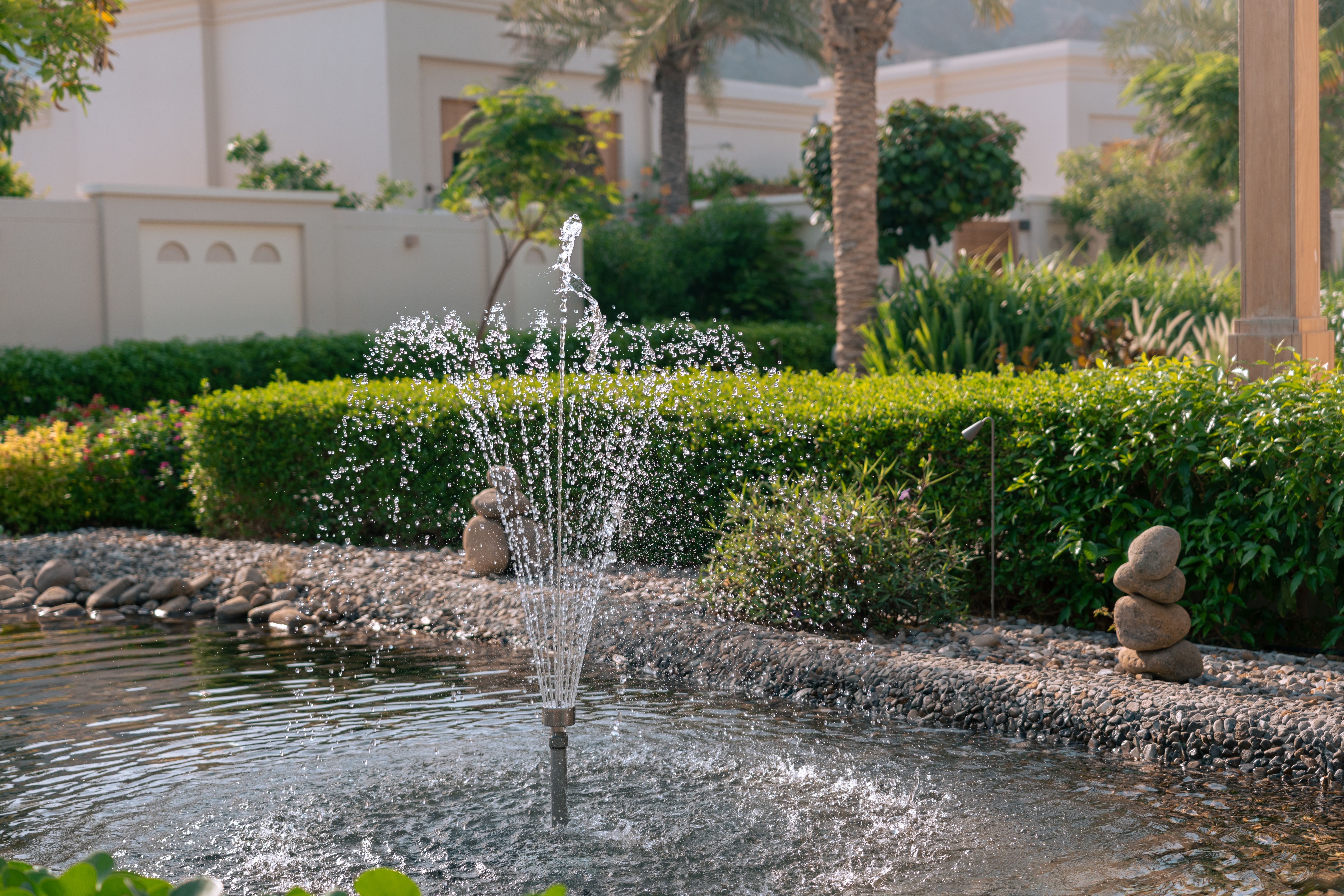 Garden fountain and pond with stone border in Dubai villa