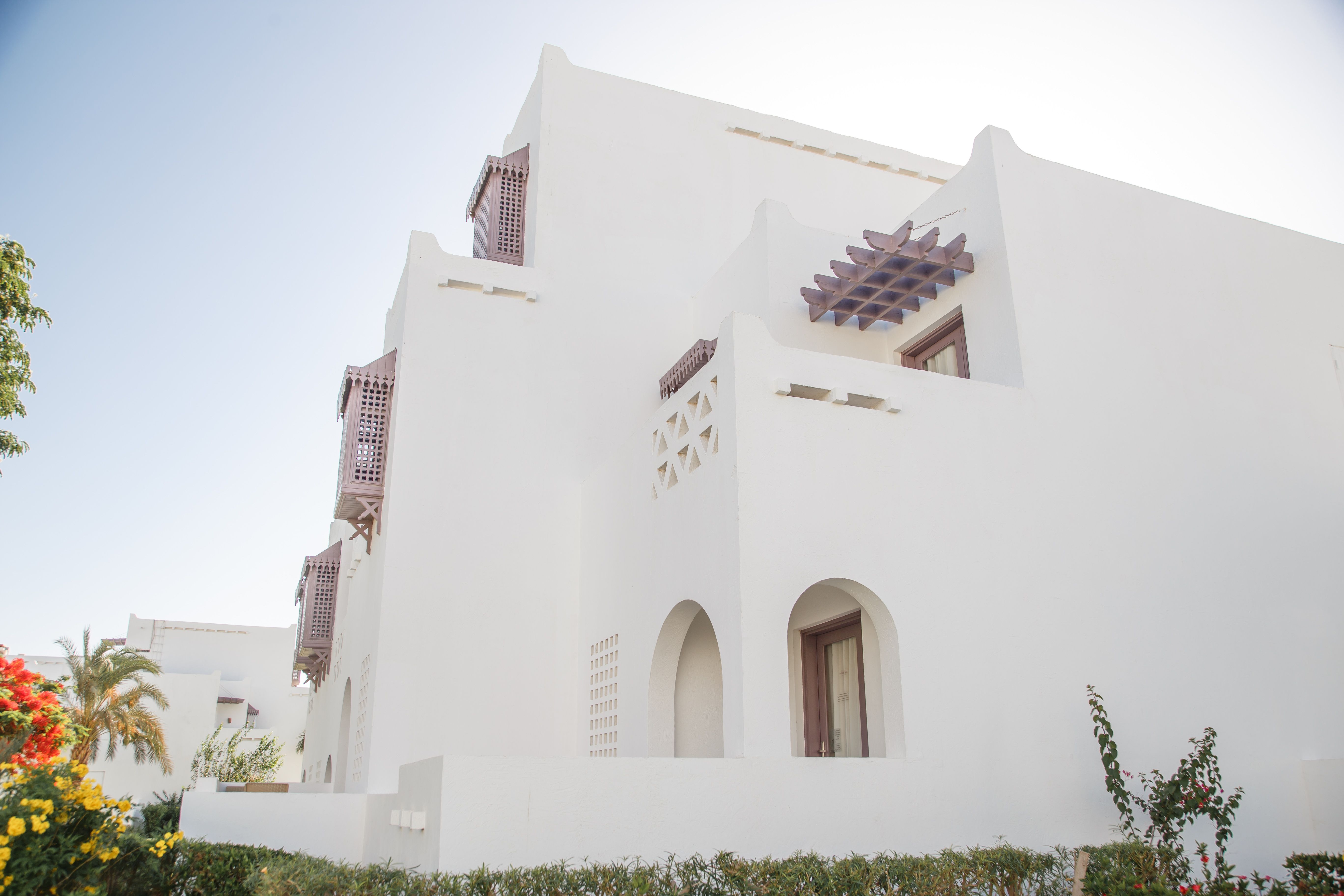 Pink villa exterior with blue shutters and balcony in Dubai