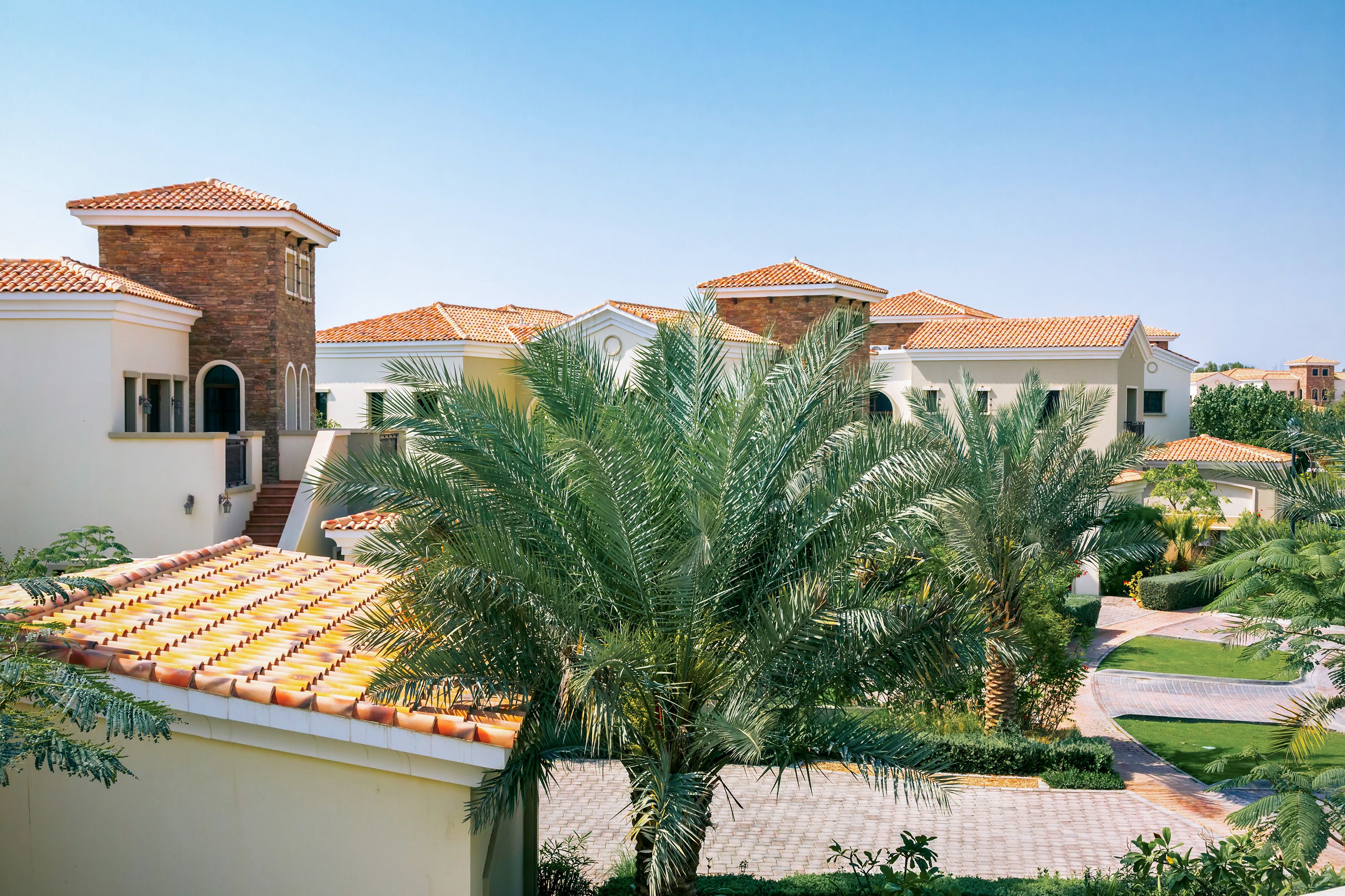 Villa extension in Dubai - terracotta-roof villa with palm-lined pathway