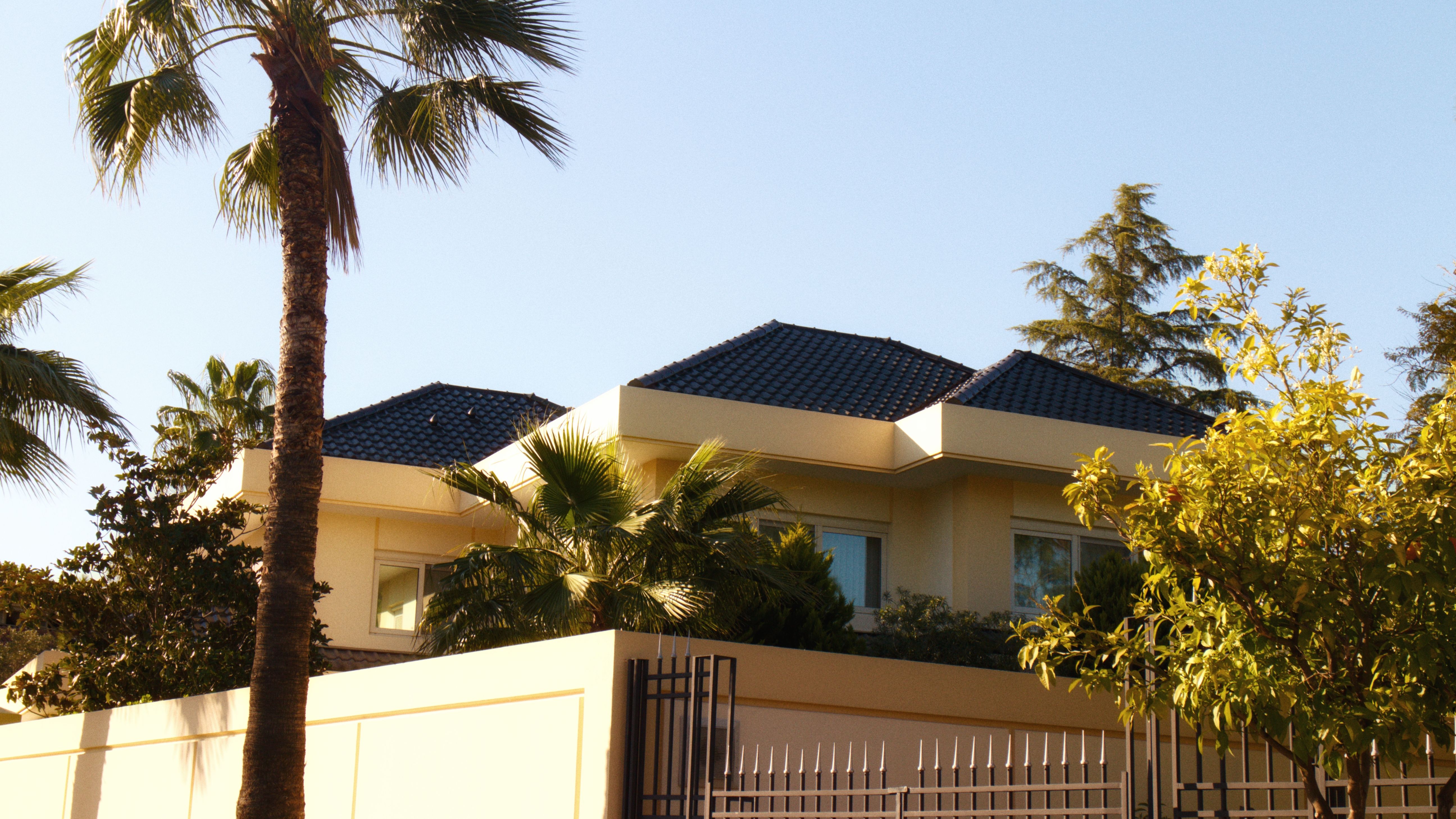 Villa extension in Dubai - beige villa with dark tiled roof and palm trees