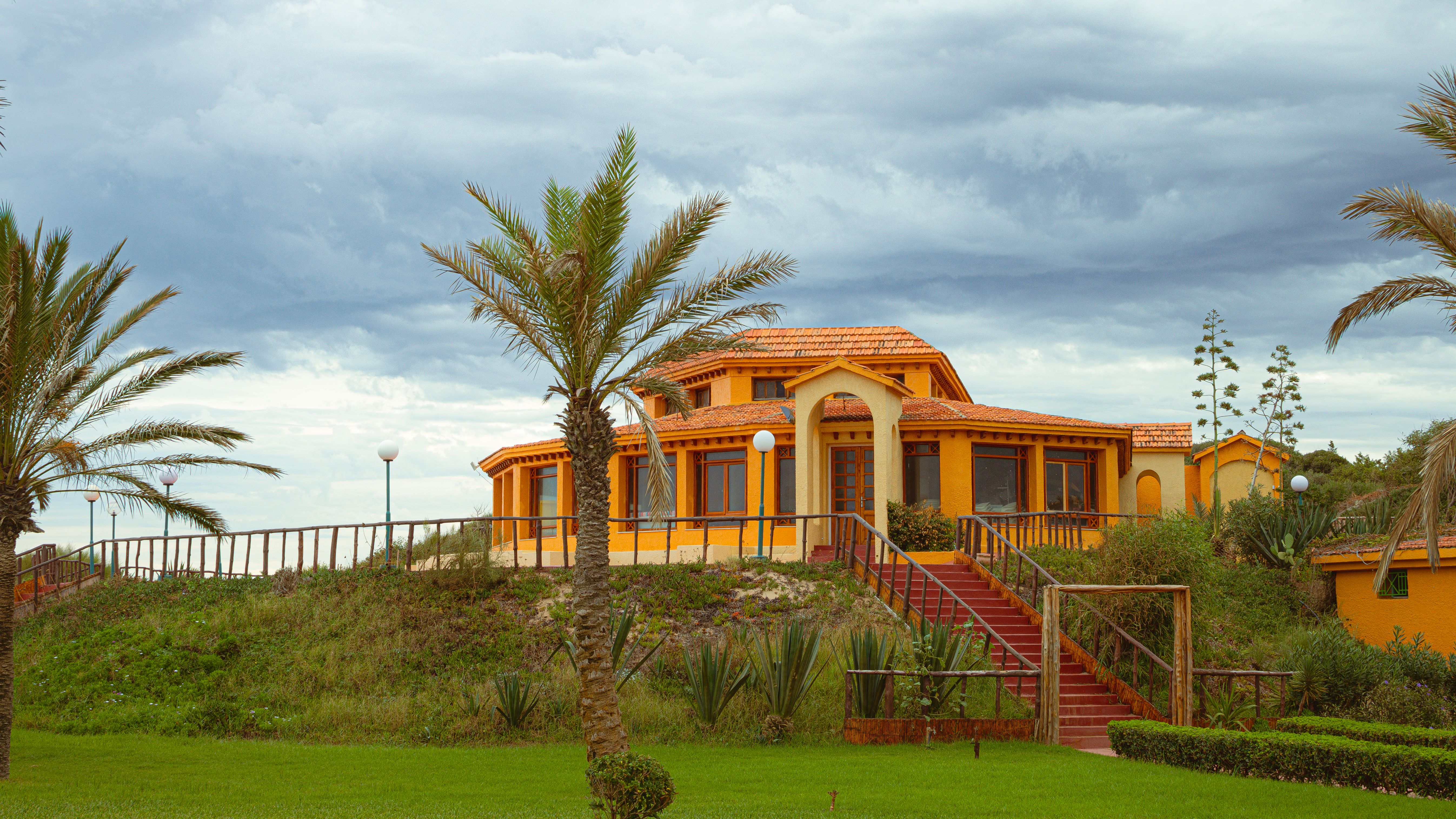 Villa extension in Dubai - orange villa with palm landscaping and red staircase